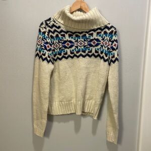 Prince and Fox woman’s cream turtleneck sweater with a colorful design